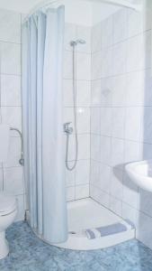 a white bathroom with a shower and a toilet at Aneton in Chrysi Ammoudia