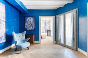 a room with blue walls and a blue chair at Galleria Vik Milano in Milan