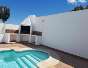 a swimming pool on the side of a house at Casa Katrina in Tías