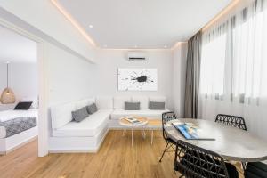 a white living room with a couch and a table at Matala Luxury Apartments in Matala