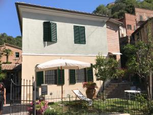 a house with green shutters and an umbrella at To dream in Siena in Siena
