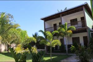 a building with palm trees in front of it at Pousada Bambui in Ituberá