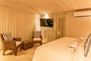 a hotel room with a bed and a chair at Casa La Merced by Mustique in Cartagena de Indias