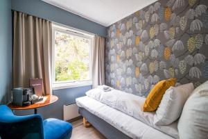 a bedroom with a couch and a wall with a window at Hotel Utsikten - by Classic Norway Hotels in Geiranger