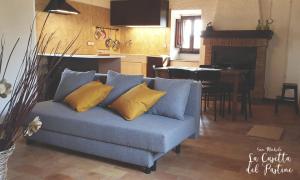 a blue couch with yellow pillows in a living room at La Casetta del Pàstine, Il Borgo Diffuso di San Michele in San Michele in Teverina