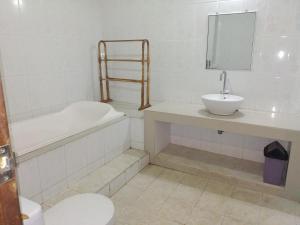 a bathroom with a toilet and a sink and a bath tub at Taman Sari Tagtag in Sanur +33 photos