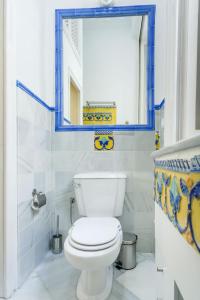 a bathroom with a white toilet and a mirror at Casa Palacio Madre de Dios in Seville