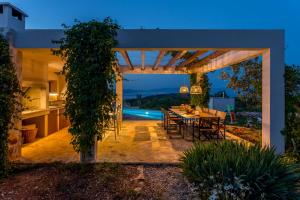a patio with a table and chairs in a backyard at Hacienda Noa in Grohote