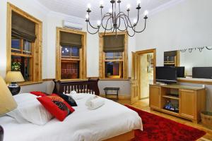 a bedroom with a large bed and a chandelier at Wilton Manor in Cape Town