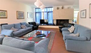 uma sala de estar com sofás azuis e uma lareira em B&B Villa Apuana em Marina di Carrara