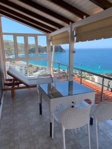 einen Tisch und Stühle auf einem Balkon mit Meerblick in der Unterkunft ★ Meniko's House ★ Amazing Sea View in Himarë