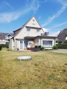 una casa con un patio con un frisbee en el césped en Ferienwohnungen Grömitz Seeweg, en Grömitz