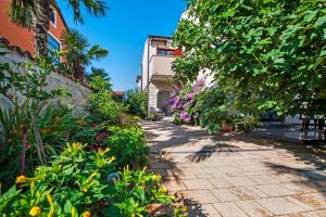 einen Gehweg durch einen Garten mit Blumen und Pflanzen in der Unterkunft Apartman Gala in Rovinj