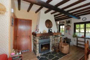 a living room with a stone fireplace in a house at Le chalet de Roanne-Coo in Stoumont