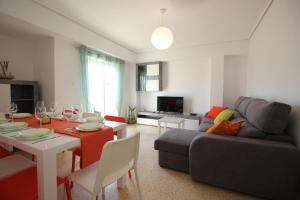 a living room with a table and a couch at Un impresionante apartamento cerca de la playa/An impressive apartment near the beach. in Puerto de Sagunto