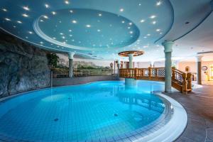 a large swimming pool in a building with a ceiling at Wellnessresort Seiwald **** Superior in Going am Wilden Kaiser