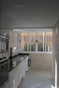 eine große Küche mit einer Spüle und einer Mikrowelle in der Unterkunft Apartamentos Lunamar in El Campello