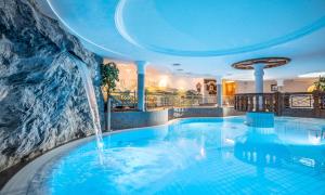 a swimming pool with a waterfall in a hotel at Wellnessresort Seiwald **** Superior in Going