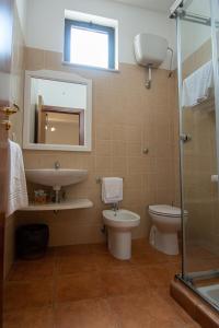 a bathroom with a sink and a toilet and a mirror at Giardino Degli Ulivi Resort Masseria in Margherita di Savoia +50 photos
