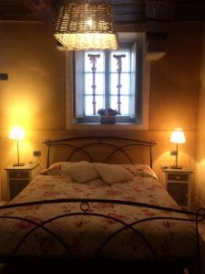 a bedroom with a bed with a window and two lamps at Villa L' Antico Torchio in Dormelletto