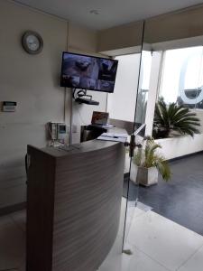a lobby with a reception desk with a tv on the wall at Beachfront Condo San Miguel in Lima