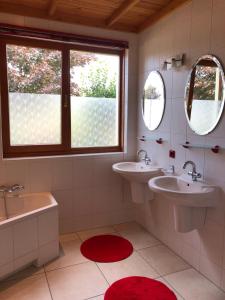 a bathroom with two sinks and a tub and two mirrors at Landgoed De Blaauwe Blaer in Hall +37 photos