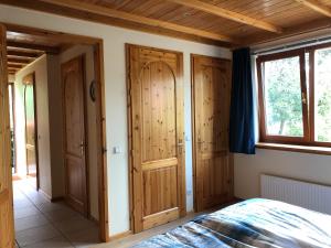 a bedroom with wooden doors and a bed in a room at Landgoed De Blaauwe Blaer in Hall