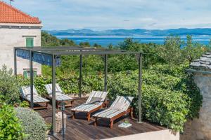 una terraza con sillas y cenador en Villa Maruka, en Supetar