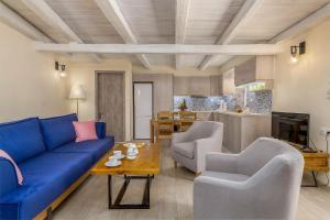 a living room with a blue couch and chairs at Diogenis House traditional vacation family place in Moírai