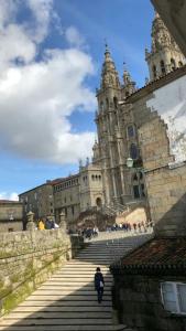 a person walking down a staircase in front of a building at Apartamento con vistas a la catedral in Santiago de Compostela