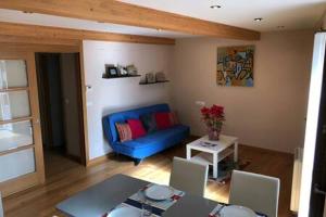 a living room with a blue couch and a table at Apartamento con vistas a la catedral in Santiago de Compostela