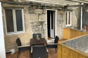 eine Terrasse mit Tisch und Stühlen vor einem Gebäude in der Unterkunft Apartamento con vistas a la catedral in Santiago de Compostela + 4 Fotos