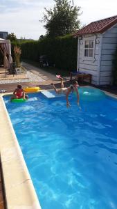 プツクにあるDom przy Basenieの二人の女の子がフリスビーと一緒にプールで遊んでいる