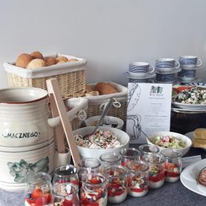 a table with bowls of food and baskets of food at Willa Moryń in Moryń