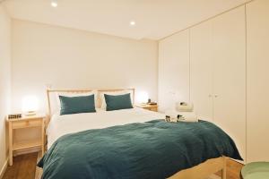 - une chambre avec un grand lit et des oreillers bleus dans l'établissement BmyGuest - Sao Bento Terrace Apartment, à Lisbonne