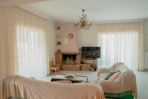 uma sala de estar com dois sofás e uma lareira em Helios Residence em Spata