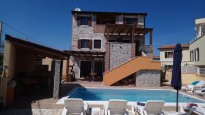 a house with a swimming pool in front of a building at Casa Bozzero in Krnica