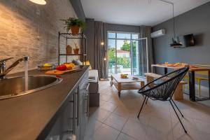 uma cozinha com um lavatório e uma sala de estar em Boutique Studios & Apartments - by Avelink em Spata