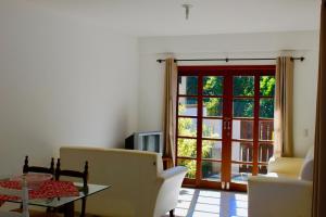 sala de estar con mesa y puerta corredera de cristal en Sobrado com piscina em Mariscal Rutilio N125, en Bombinhas