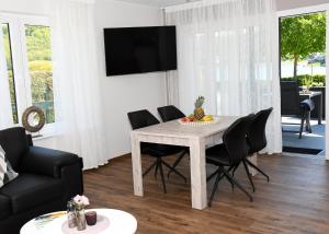 ein Wohnzimmer mit einem Tisch und Stühlen in der Unterkunft Zum Anker in Simmerath