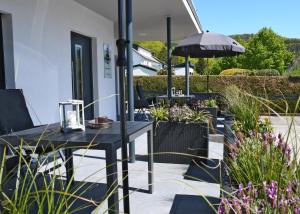 eine Terrasse mit einem Tisch und einem Sonnenschirm in der Unterkunft Zum Anker in Simmerath