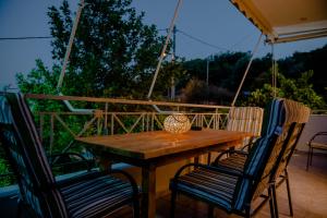 a wooden table with two chairs and a vase on it at Helios Residence in Spata