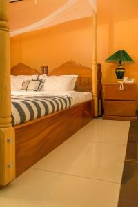 a bedroom with a bed with a wooden frame at Kayegi Hotel Mbale in Mbale