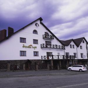 a white building with a car parked in front of it at Золота Гора in Starunya