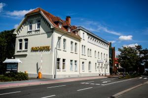 a large white building on the side of a street at Parkhotel Lingen in Lingen