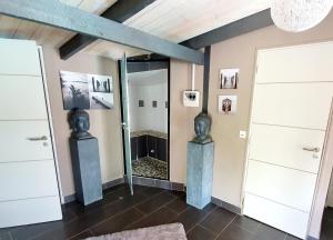 a room with two statues in front of a mirror at Le Petit Moulin du Rouvre in Saint-Pierre-de-Plesguen