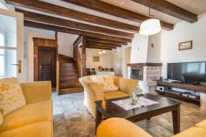 Una sala de estar con sofás, un televisor y una mesa. en Villa Maruka, en Supetar