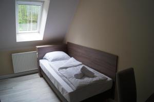 Dormitorio pequeño con cama y ventana en Hotel Tini en Bad Fallingbostel
