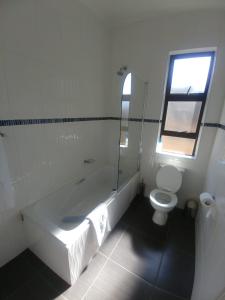 a bathroom with a toilet and a sink and a window at Scenery Guest House in Kokstad +22 photos