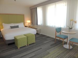 une chambre d'hôtel avec un lit, une table et des chaises dans l'établissement The Inn at Longwood Medical, à Boston